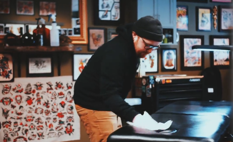 Tattoo artist cleaning a chair.