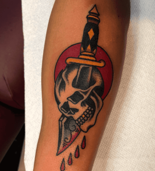 A tattoo of a dagger through a skull.