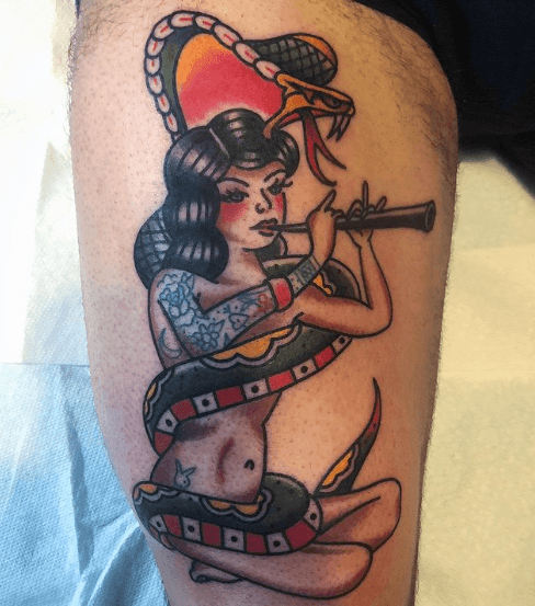 A tattoo of a woman charming a snake by playing a pungi.