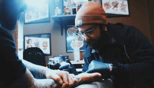 Artist tattoing a wrist.