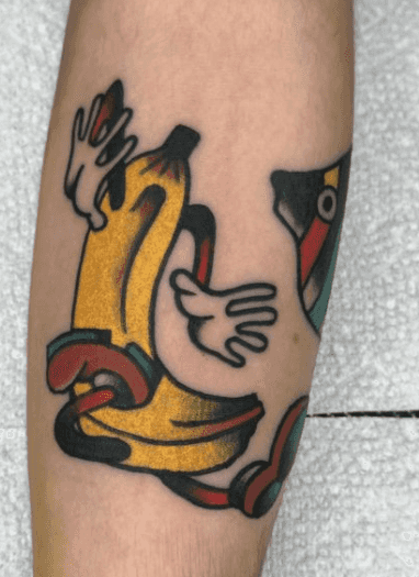 Tattoo of a cartoon banana slipping and falling.