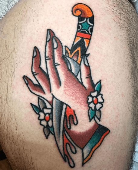 A tattoo of a hand with a dagger through it.