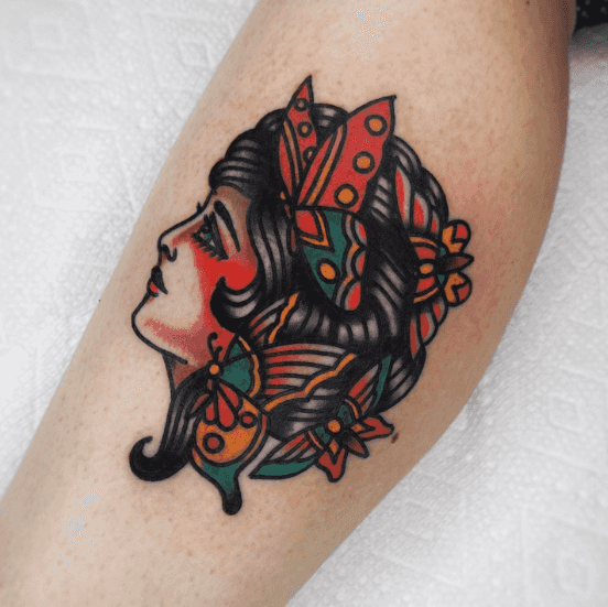 A tattoo of a woman's profile with butterflies in her hair.