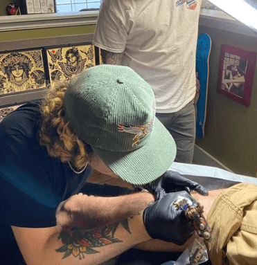 Artist tattooing a leg.