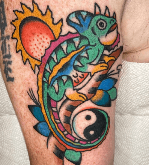 A tattoo of chameleon with a ying yang symbol.